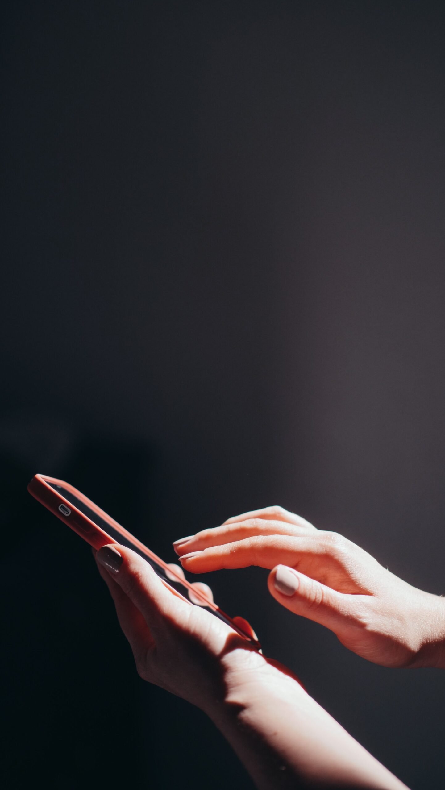 Hands interacting with a smartphone in a well-lit setting, emphasizing connection and technology.